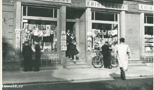 Foto z roku 1948 dokumentuje pozdější značné zvýšení hlavní silnice v Krkonošské ulici v Tanvaldě, neboť do obchodů a domů, včetně kina, se vstupovalo po schodech.